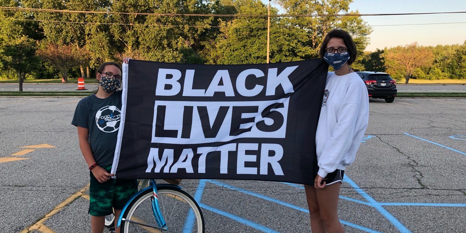 Zoe and Ruby hold BLM flag